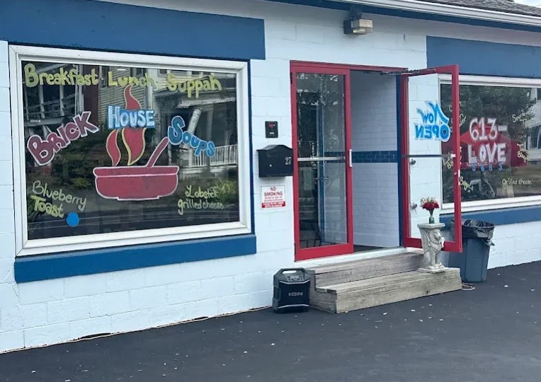 The storefront in its opening days, with a hand-painted soup bowl logo on the window and red door frames
